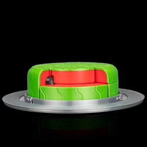 May include: A green and red watermelon-shaped container with a silver base. The container is cut to reveal the red interior. The green exterior has a textured design. The container is on a silver plate.