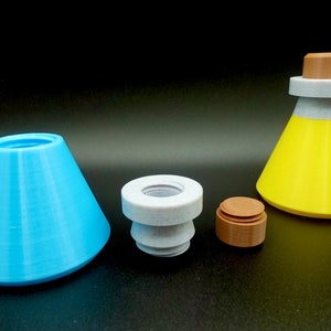 May include: A collection of 3D-printed potion bottles and components in various colors. Includes a light blue cone, a gray bottle stopper, a brown cap, and a yellow bottle with a gray and brown top. The objects are on a black surface.
