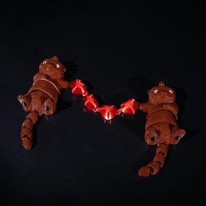 3D-Printed Love Otters Holding Hearts String