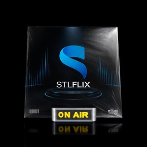 May include: A black album cover with a blue 'S' logo and the text 'STLFLIX'. Below, a silver 'ON AIR' sign with yellow text is displayed. The image is set against a black background.