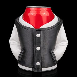 May include: A red soda can is dressed in a black and white varsity jacket with three white buttons. The jacket has white sleeves and a white collar. The background is black.