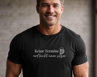 Op de afbeelding: Zwart T-shirt met witte tekst en een bierpul-afbeelding. De tekst luidt "Keine Termine und leicht einen sitzen". Het shirt is gemaakt van een zacht materiaal en is geschikt voor casual wear.