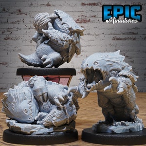 May include: Three gray miniature fantasy creatures with detailed textures. One is coiled with a rope, another is mid-attack with open jaws and claws, and the third is curled up. The Epic Miniatures logo is visible in the background.