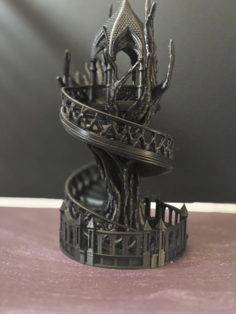 Pode incluir: Uma torre de fantasia preta impressa em 3D com uma escada em espiral e detalhes ornamentados. A torre apresenta uma estrutura semelhante a uma &aacute;rvore que suporta a escada e um topo semelhante a um gazebo. A base tem uma cerca decorativa.