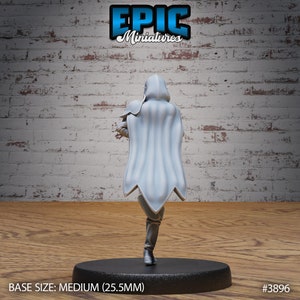 Puede incluir: Una miniatura impresa en 3D blanca de una figura con capucha y una capa fluida, de pie sobre una base negra. La miniatura tiene un tama&ntilde;o de 25,5 mm. El texto "EPIC Miniatures" y "#3896" son visibles en la imagen.