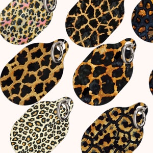 May include: A set of seven keychains featuring different animal print designs. The keychains are made of a durable material and have a silver ring for attaching keys. The designs include leopard print, cheetah print, zebra print, and giraffe print.