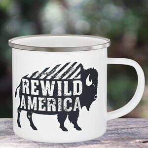 May include: White enamel mug with a silver rim featuring a black and white illustration of a bison with the text "REWILD AMERICA" printed on it.