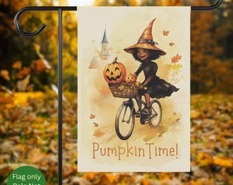May include: A garden flag featuring a watercolor illustration of a witch riding a bicycle with pumpkins in the basket. The flag has the text "Pumpkin Time!" and is set against a blurred autumn background.