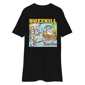 May include: Black t-shirt with a vibrant graphic. The design includes the word "BUZZKILL" in yellow, above a cartoon illustration. The words "TOOTH SOLE" are in blue below the illustration.