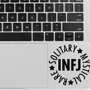 May include: A black and white sticker on a silver laptop. The sticker is a circle with the words "SOLITARY MYSTICAL RARE" around the outside and "INFJ" in the center.