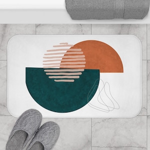 Peut inclure: Tapis de bain abstrait avec un fond blanc, un demi-cercle bleu sarcelle, un demi-cercle orange brûlé et un cercle rayé rose et orange.