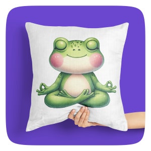 Op de afbeelding: Een wit kussen met een groene kikker die erop mediteert. De kikker heeft zijn ogen dicht en een vredige uitdrukking. Het kussen is een geweldige aanvulling op elk interieur.