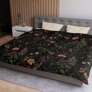 Puede incluir: Una funda nórdica negra con un patrón floral con flores rosas, amarillas y verdes sobre un fondo oscuro.
