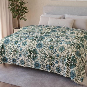 May include: A white duvet cover with a blue and green floral pattern. The duvet cover is on a bed with white pillows.