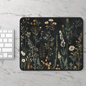 Puede incluir: Una alfombrilla de ratón negra con un diseño floral que presenta margaritas blancas y otras flores silvestres sobre un fondo verde oscuro.