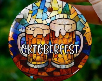 May include: A round ceramic bauble with a stained glass design featuring two beer mugs with the text "Oktoberfest".