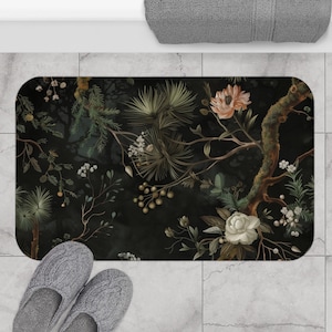 Può includere: Un tappetino da bagno nero con un motivo floreale con fiori e foglie bianchi, rosa e verdi su uno sfondo scuro.