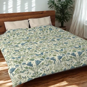 May include: A bed with a wooden headboard and a floral patterned duvet cover. The duvet cover features a cream background with blue and green floral designs. Two beige pillows are on the bed.