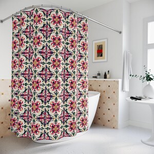 May include: A shower curtain with a repeating floral pattern in shades of pink, purple, green, and yellow on a cream background. The curtain is hanging in front of a white bathtub, with a curved shower rod.