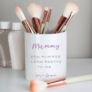 Può includere: Portapennelli da trucco in ceramica bianca con il testo "Mummy You Always Look Pretty To Me Love Grace" in viola. Il portapennelli è pieno di pennelli da trucco color oro rosa.