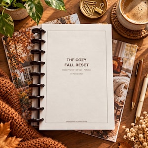 May include: A disc-bound planner with a white cover featuring the text THE COZY FALL RESET, October Planner, Self-Care, Reflection, and Ink-Friendly Edition. The planner has a black plastic spine and is positioned on a wooden surface.
