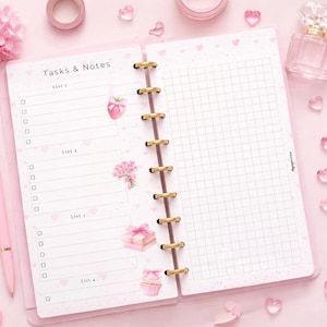 May include: A pink open notebook with the text "Tasks & Notes" and a grid-lined page. The notebook is surrounded by pink accessories, including a pen, scissors, tape, and heart-shaped decorations. A floral arrangement and perfume bottle are also present.