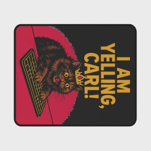 Op de afbeelding: Zwart rechthoekig mousepad met een cartoonkat met een kroon en schreeuwend naar een toetsenbord. De tekst "I AM YELLING, CARL!" is in goud gedrukt. De achtergrond is rood en zwart.