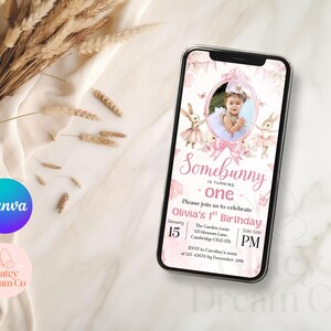 May include: A pink and white digital invitation with a photo of a baby girl in a pink tutu and bunny ears. The text reads "Somebunny is turning one. Please join us to celebrate Olivia's 1st Birthday. January 15, 5:00 PM. The Garden Room, 225 Blossom Lane, Cambridge CB25 1FB. RSVP to Caroline's mum at 123 45678 by December 28th."