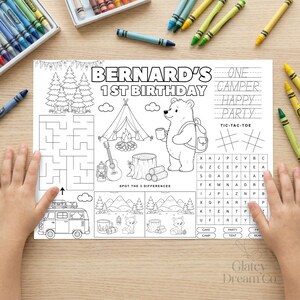 Può includere: Un foglio di attività in bianco e nero intitolato Bernard's 1st Birthday con un orso, una tenda, un falò, una chitarra, un labirinto, un cruciverba e un gioco delle differenze. Include testo da ricalcare e un'illustrazione di un camper.