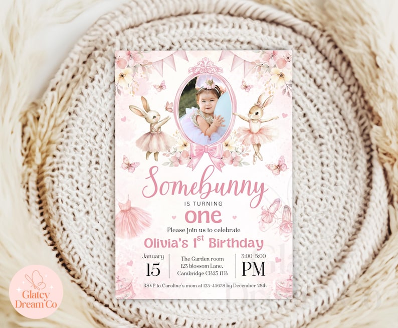 May include: Pink and white birthday invitation with a photo of a child in a pink dress. The invitation says "Somebunny is turning one. Please join us to celebrate Olivia's 1st Birthday. January 15, 3:00-5:00 PM. The Garden room, 125 Blossom Lane, Cambridge CB25 ITB. RSVP to Caroline's mum at 123-45678 by December 28th."