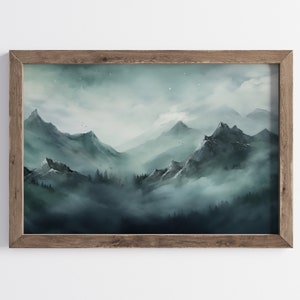 May include: A framed print of a misty mountain landscape with a dark blue and green color scheme. The mountains are covered in fog and the sky is a light blue with a few stars.