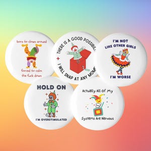 May include: A collection of five white round buttons with colorful clown-themed illustrations and humorous phrases. The buttons feature images of clowns and text like "I'm not like other girls, I'm worse."