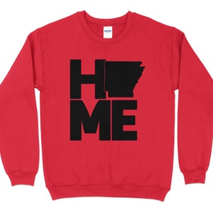 Puede incluir: Sudadera roja con texto negro que dice "HOME" con la "O" reemplazada por el contorno del estado de Arkansas.
