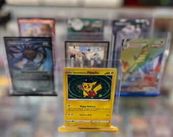 Könnte beinhalten: Eine gelbe Pokemon-Sammelkarte mit Pikachu, das einen Hut trägt und ein Paket trägt. Die Karte trägt den Titel "Special Delivery Pikachu" und hat eine Stärke von 60. Die Karte hat eine Attacke namens "Happy Delivery" und eine weitere Attacke namens "Electro Ball" mit einer Stärke von 30.