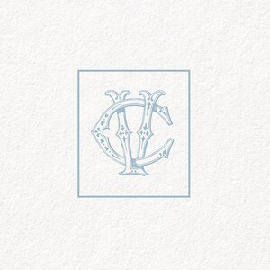 May include: A blue monogram with the letters "VC" in a decorative, ornate font inside a blue square frame.