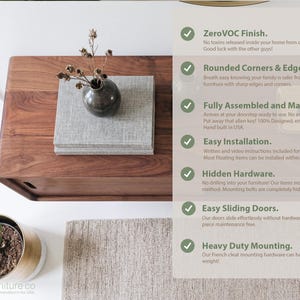 K&ouml;nnte beinhalten: Ein rechteckiges Medienm&ouml;bel aus Holz mit Schiebet&uuml;ren, darauf ein mit grauem Stoff bezogenes Buch und eine dunkle Vase mit getrockneten Stielen. Der Text listet Merkmale auf: ZeroVOC Finish, Rounded Corners & Edges, Fully Assembled, Easy Installation, Hidden Hardware, Easy Sliding Doors und Heavy Duty Mounting.