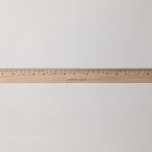 May include: A wooden ruler with markings from 1 to 18 inches. The ruler is labeled "Consent Ruler".