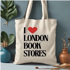 Può includere: Una borsa tote in tela bianca con testo nero che recita "I ♥ LONDON BOOK STORES". Il cuore è rosso.