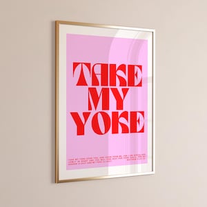 May include: Framed art print with a pink background and bold red text that reads "TAKE MY YOKE". The print includes a Bible verse at the bottom. The frame is gold.