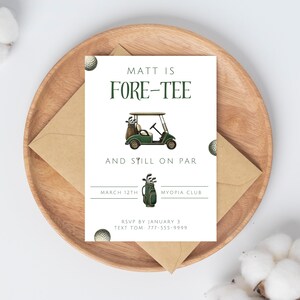 May include: A white invitation card with green text that reads "Matt is Fore-Tee and still on par". The card features a cartoon golf cart with golf clubs and a golf bag. The date "March 12th" and the location "Myopia Club" are printed on the card. The text "RSVP by January 3 Text Tom 777-555-9999" is also printed on the card.