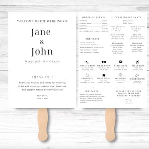 May include: A wedding program fan with a wooden handle. The front features the names "Jane & John" and wedding details. The back includes the order of events, wedding party, and fun facts. The text is in black on a white background.