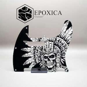 May include: Black and white guitar pickguard featuring a skull and feather design. The pickguard has a unique shape and the text "EPOXICA Guitars" is at the top. The design includes a detailed skull with headdress.