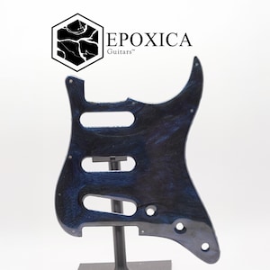 May include: A blue and black guitar pickguard with a marbled design. The pickguard has three oval cutouts and several screw holes. The logo "EPOXICA Guitars" is in the upper left corner.