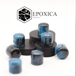 May include: A collection of guitar knobs with a blue and black marbled design. The knobs are cylindrical and have a glossy finish. The image also displays the "EPOXICA Guitars" logo.