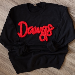 May include: Black sweatshirt with a red fuzzy applique that says "Dawgs".