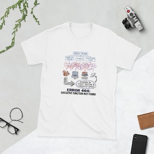 Può includere: T-shirt bianca con un design grafico raffigurante un diagramma del piano giornaliero e la scritta "ERROR 404: EXECUTIVE FUNCTION NOT FOUND". Il design include uno scoiattolo, un laptop, libri e altri elementi.