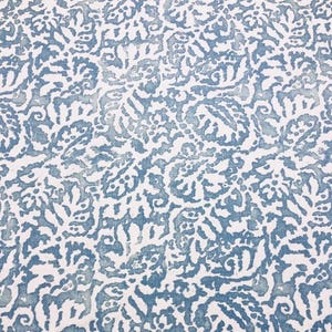 Könnte beinhalten: Ein weißer Stoff mit einem blauen Blumenmuster. Das Muster ist ein sich wiederholendes Design aus stilisierten Blumen und Blättern.