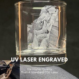 Peut inclure: Un verre cylindrique transparent avec une image grav&eacute;e au laser UV d&eacute;taill&eacute;e d'une personne. Le texte "UV LASER ENGRAVED" est affich&eacute; sur le verre. L'image comprend &eacute;galement le texte "10x Higher Quality Than A Standard CO2 Laser".