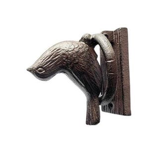 May include: A brown cast iron door knocker shaped like a bird. The bird has detailed feathering and a curved beak. The knocker includes a ring and a mounting plate for door installation.