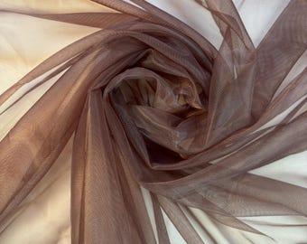 May include: A sheer brown fabric with a shimmery finish. The fabric is draped and folded, showing its texture and drape.